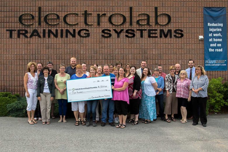 Electrolab employees holding a large check