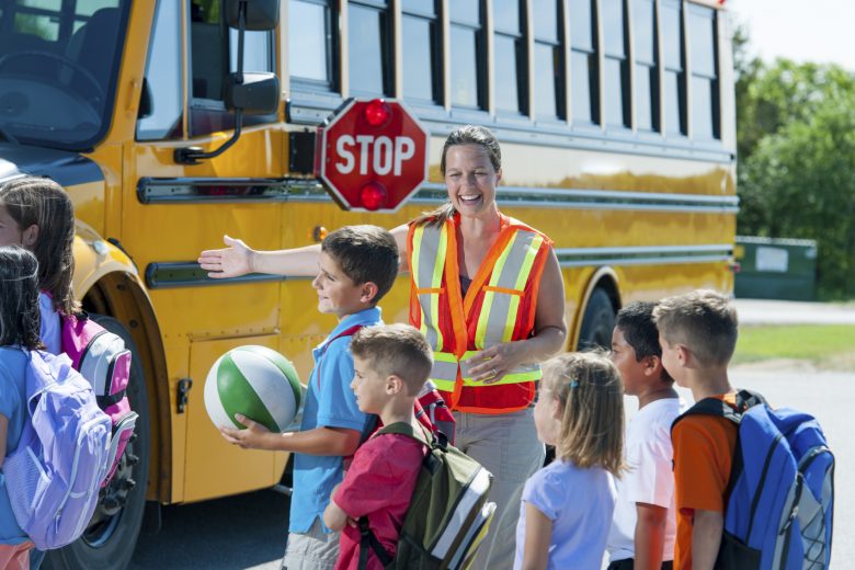 Really happy people beside a school bus