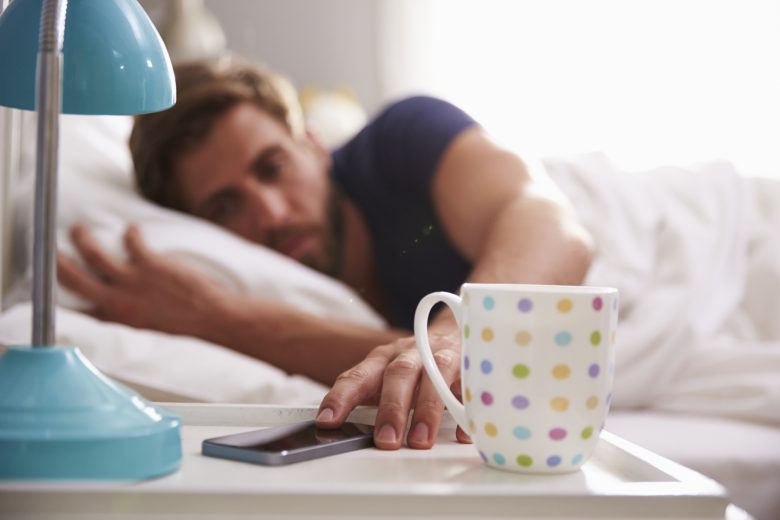 An on-call worker reaches for the snooze button on his phone