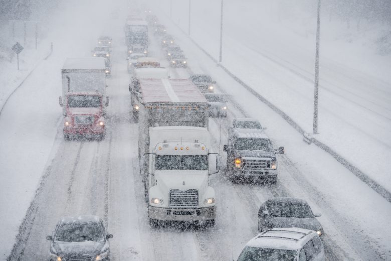 A truck drives on a crowded highway in the winter