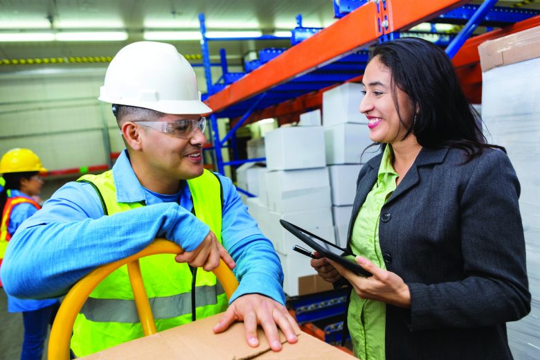 A worker and management member having a conversation in a warehouse