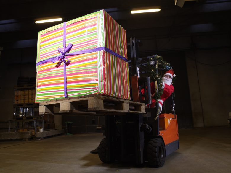 Santa driving a forklift with a big present on the load