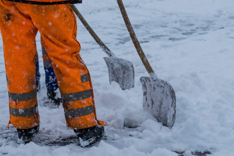 Construction workers shoveling snow