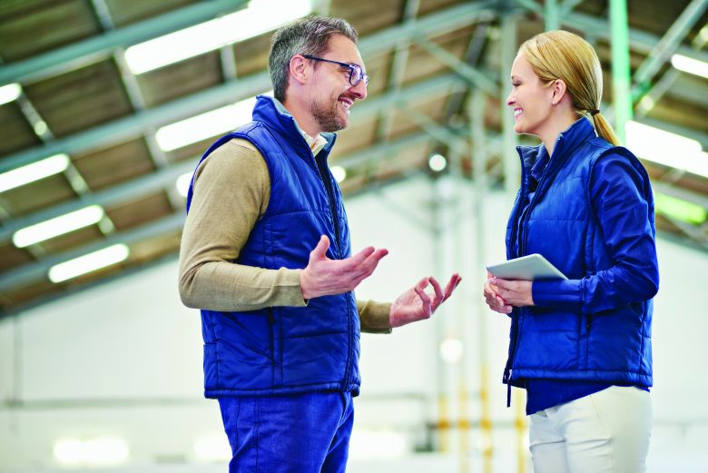 Two people having a conversation in a warehouse