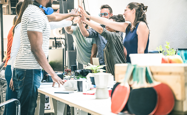 Young employee startup workers group stacking hands at urban studio - start up meeting