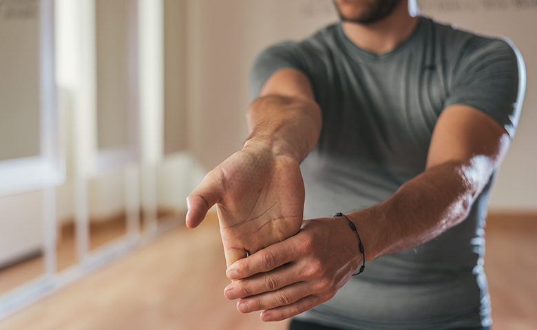 Man stretching forearm and hand