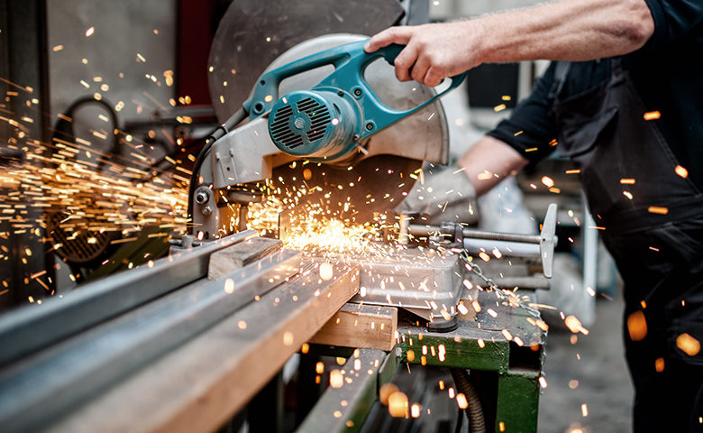 man, worker using a sliding compound mitre saw