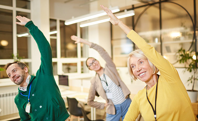 Active company employees exercising in office