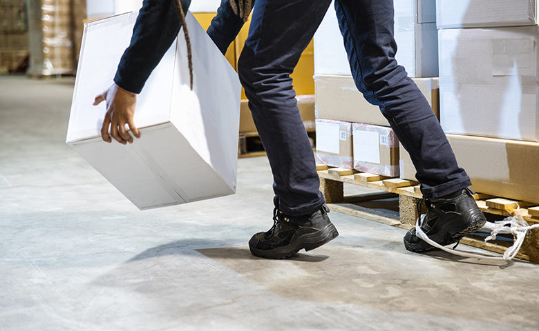 A warehouse worker tripping and falling beside a pallet