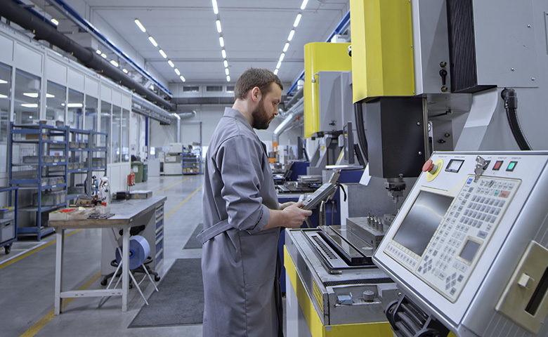 Worker operating remote control while standing