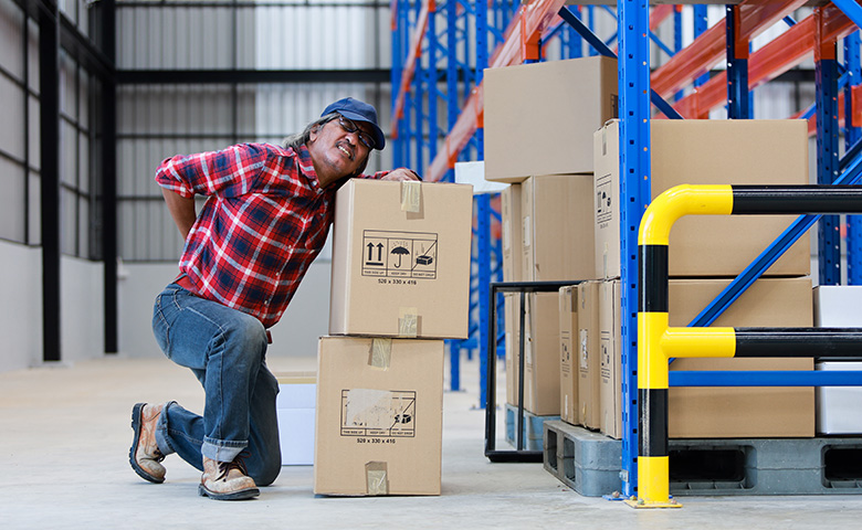 Worker hurt his back lifting heavy box in factory