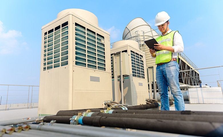 Worker doing preventive maintenance rooftop inspection